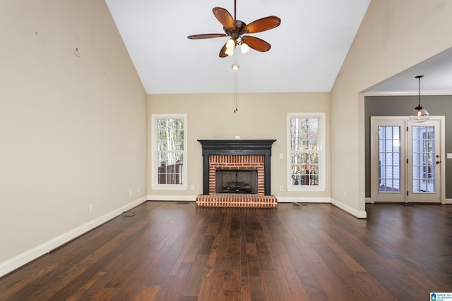 unfurnished living room with a ceiling fan, baseboards, high vaulted ceiling, a fireplace, and dark wood-style flooring
