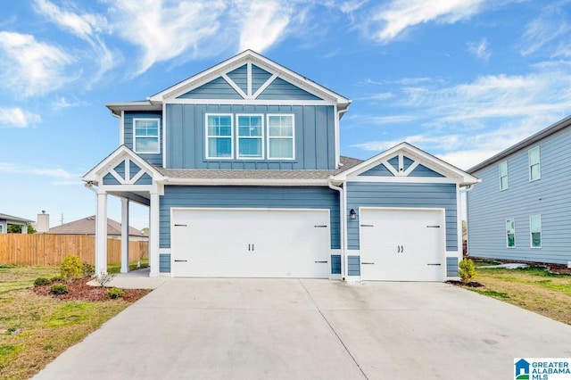 view of front of property with a garage, fence, board and batten siding, and driveway