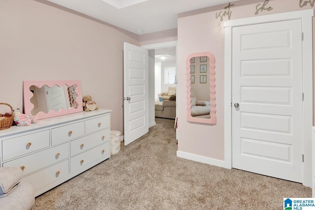 bedroom with light colored carpet and baseboards