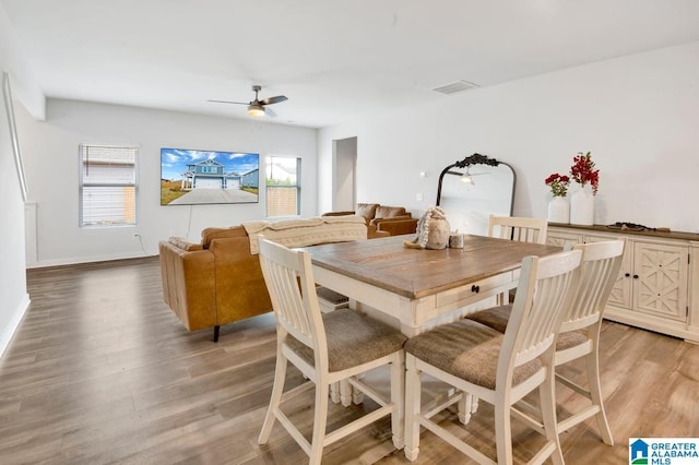 dining area featuring visible vents, light wood-style flooring, baseboards, and ceiling fan