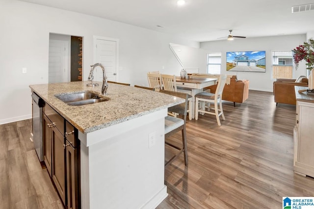 kitchen with wood finished floors, visible vents, ceiling fan, a sink, and dishwasher