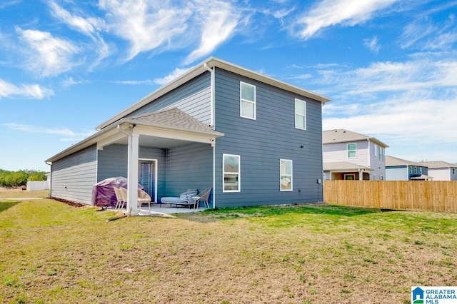 rear view of house with a patio area, a lawn, and fence