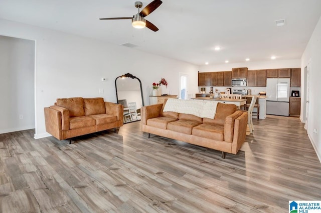 living room with light wood-style flooring, recessed lighting, visible vents, and ceiling fan