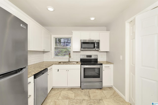 563 Brussels Ave, Birmingham, AL 35212 - kitchen with a sink, decorative backsplash, appliances with stainless steel finishes, and white cabinetry