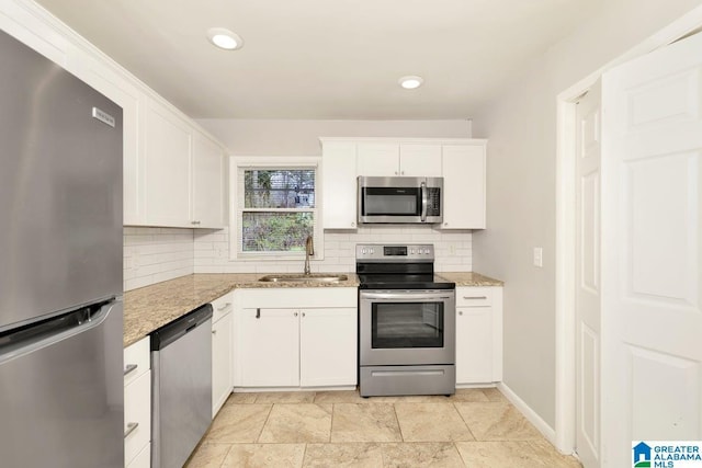 563 Brussels Ave, Birmingham, AL 35212 - kitchen with tasteful backsplash, light stone countertops, stainless steel appliances, white cabinetry, and a sink