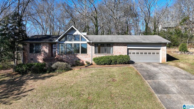 view of front of home with brick siding, driveway, a front yard, and a garage