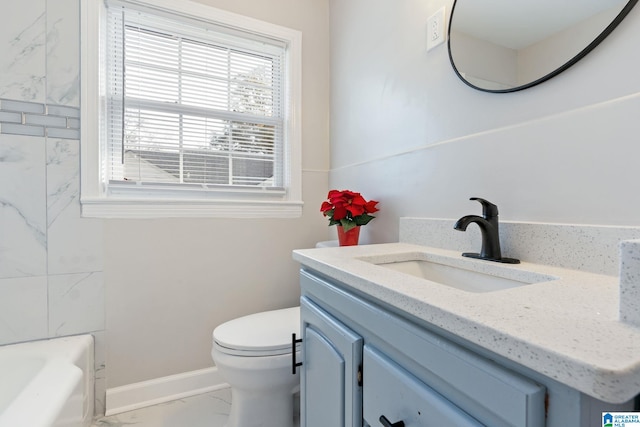 bathroom featuring baseboards, toilet, a bathtub, marble finish floor, and vanity