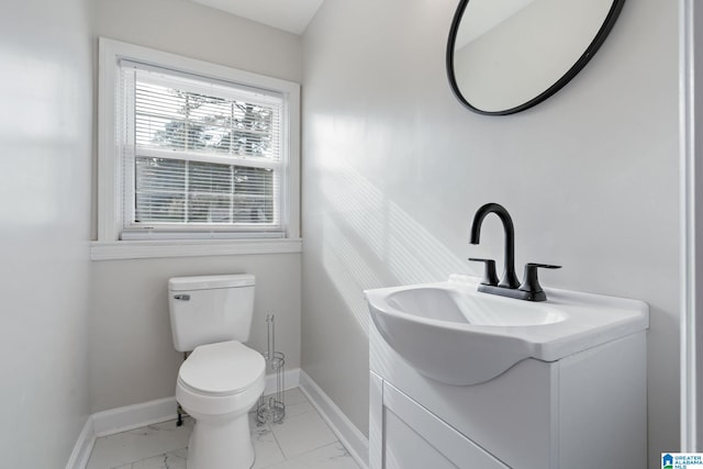 bathroom featuring marble finish floor, toilet, vanity, and baseboards