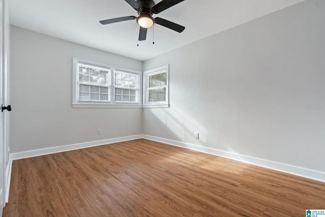 spare room with a ceiling fan, wood finished floors, and baseboards