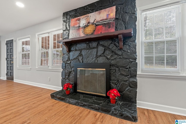 interior details with baseboards, wood finished floors, and a fireplace