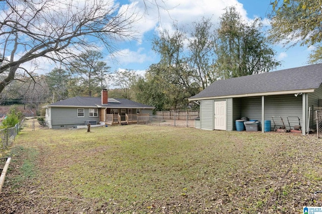 view of yard with a wooden deck, a fenced backyard, and an outdoor structure