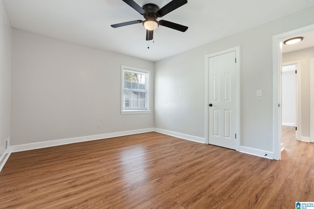 unfurnished bedroom with ceiling fan, baseboards, and light wood-style floors