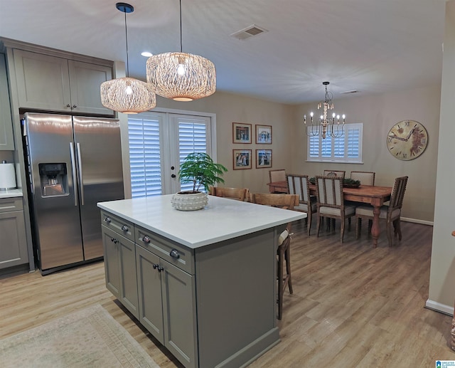 2365 Jim Raney Ln, Bessemer, AL 35023 - kitchen featuring stainless steel fridge with ice dispenser, visible vents, an inviting chandelier, light countertops, and gray cabinetry