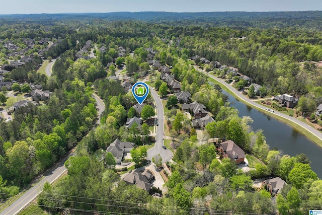 drone / aerial view featuring a view of trees, a residential view, and a water view