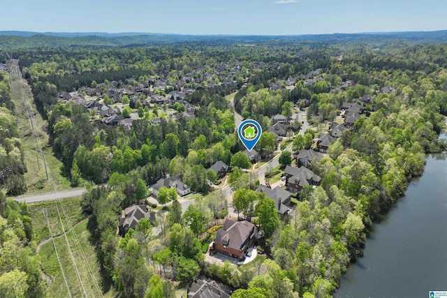 bird's eye view featuring a water view, a residential view, and a wooded view