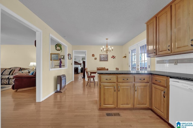 2350 Morton Rd, Warrior, AL 35180 - kitchen with dark countertops, light wood-style floors, a peninsula, white dishwasher, and a chandelier