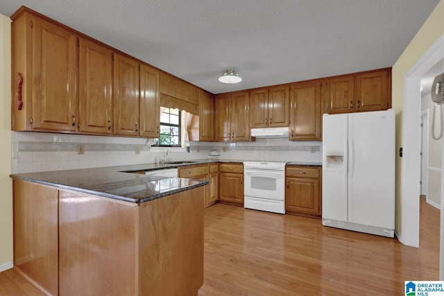 2350 Morton Rd, Warrior, AL 35180 - kitchen featuring under cabinet range hood, white appliances, brown cabinets, and a peninsula