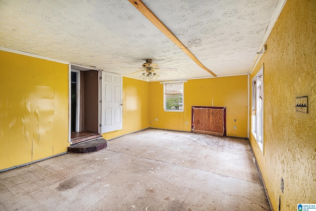 empty room with a textured ceiling, ceiling fan, and crown molding