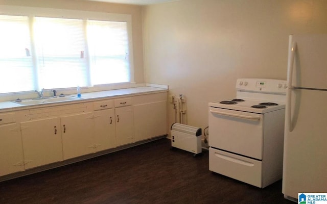 kitchen featuring dark wood-type flooring, light countertops, white cabinets, white appliances, and a sink