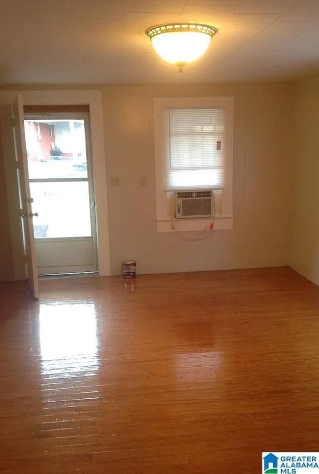 spare room featuring cooling unit and wood finished floors