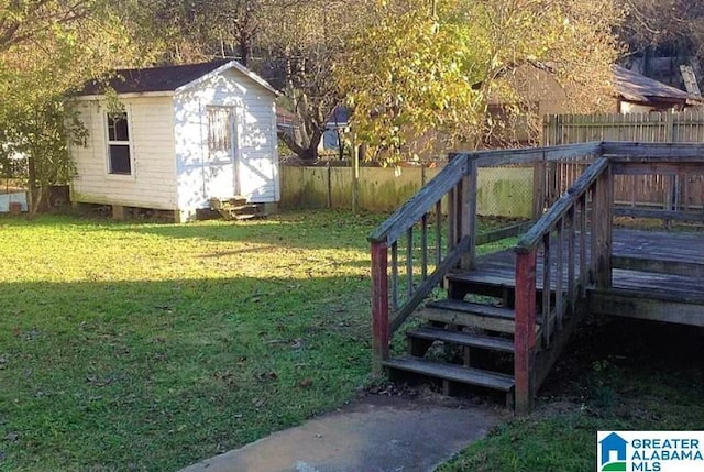 view of yard featuring an outbuilding, a fenced backyard, a shed, and a wooden deck