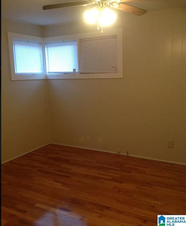 unfurnished room with wood finished floors and a ceiling fan