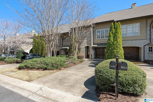 view of building exterior with concrete driveway and a garage