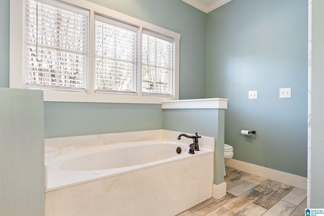 bathroom with a bath, wood finished floors, baseboards, ornamental molding, and toilet