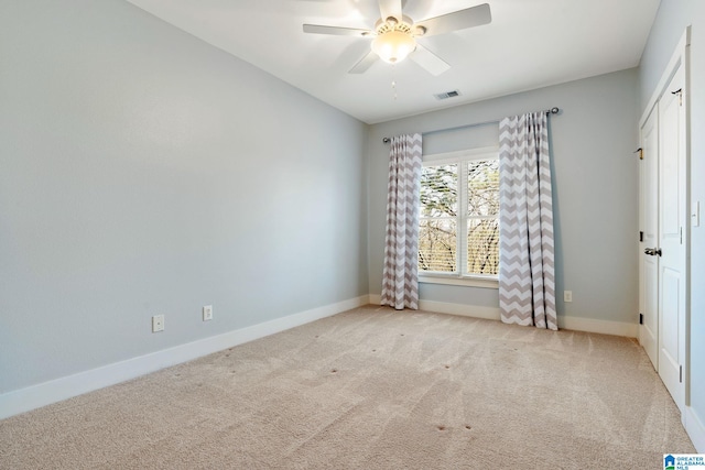 carpeted empty room with a ceiling fan, baseboards, and visible vents