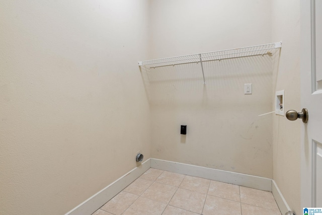 washroom with hookup for a washing machine, light tile patterned floors, baseboards, hookup for an electric dryer, and laundry area