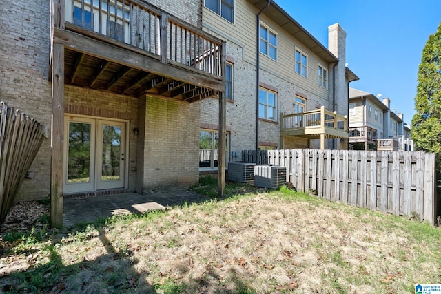 view of yard featuring french doors, central AC, and fence