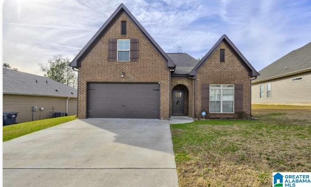 view of front of home with concrete driveway, a front lawn, an attached garage, and brick siding