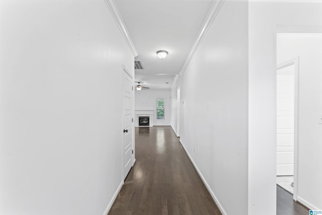 corridor with visible vents, crown molding, dark wood-style floors, and baseboards