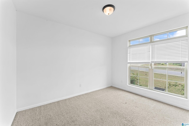 carpeted spare room featuring baseboards