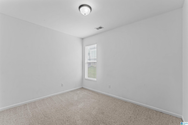 carpeted empty room with visible vents and baseboards
