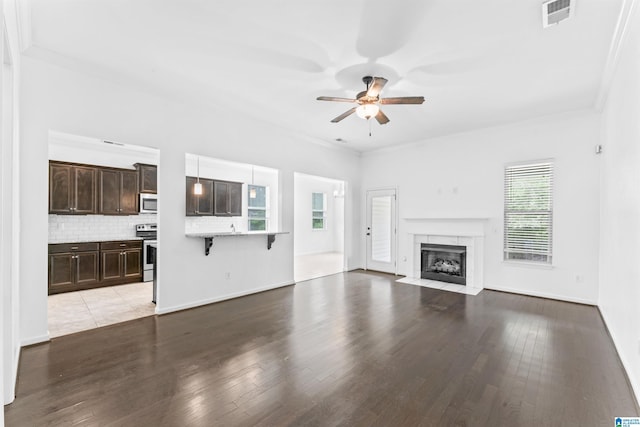 unfurnished living room with visible vents, ornamental molding, ceiling fan, and light wood finished floors