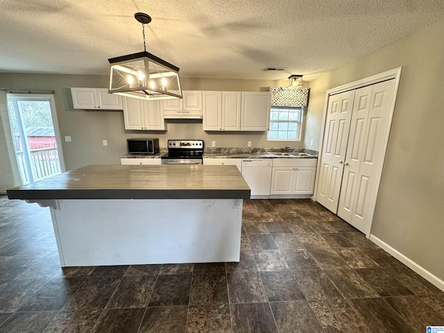 kitchen with under cabinet range hood, white cabinets, dark countertops, and appliances with stainless steel finishes