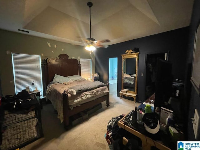bedroom with a ceiling fan, visible vents, light carpet, a raised ceiling, and access to outside