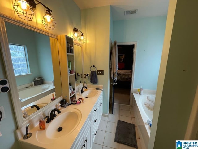 ensuite bathroom featuring tile patterned flooring, a garden tub, and a sink
