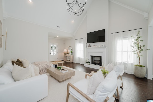 2167 Springfield Dr, Chelsea, AL 35043 - living room featuring high vaulted ceiling, crown molding, a fireplace with raised hearth, wood finished floors, and an inviting chandelier