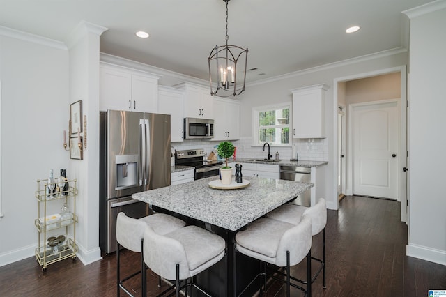 2167 Springfield Dr, Chelsea, AL 35043 - kitchen with crown molding, a kitchen bar, stainless steel appliances, a kitchen island, and a sink