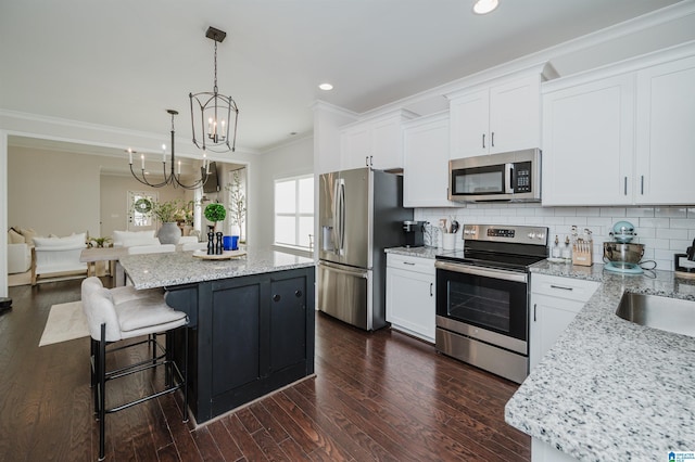 2167 Springfield Dr, Chelsea, AL 35043 - kitchen with crown molding, a kitchen island, appliances with stainless steel finishes, dark wood finished floors, and decorative backsplash