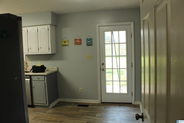 doorway featuring wood finished floors, baseboards, and visible vents