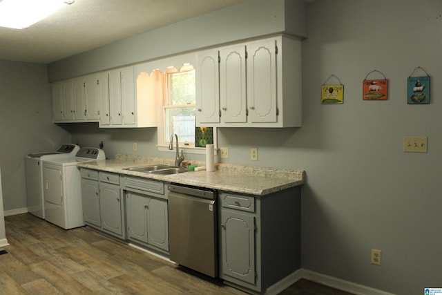 kitchen with gray cabinets, washer and dryer, dishwasher, a sink, and wood finished floors