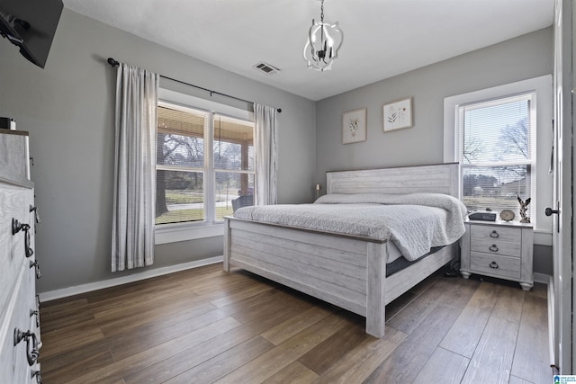 1109 Central Ave, Gadsden, AL 35904 - bedroom with a notable chandelier, visible vents, dark wood-type flooring, and baseboards