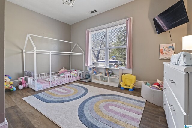 1109 Central Ave, Gadsden, AL 35904 - bedroom featuring a nursery area, wood finished floors, visible vents, and baseboards