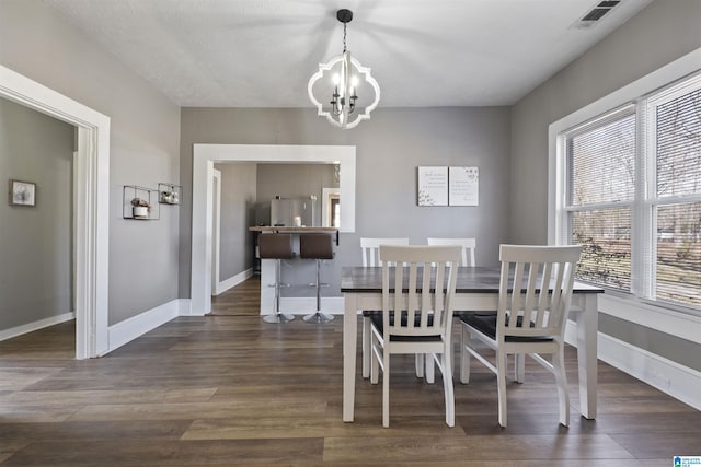 1109 Central Ave, Gadsden, AL 35904 - dining area featuring baseboards, wood finished floors, visible vents, and a chandelier