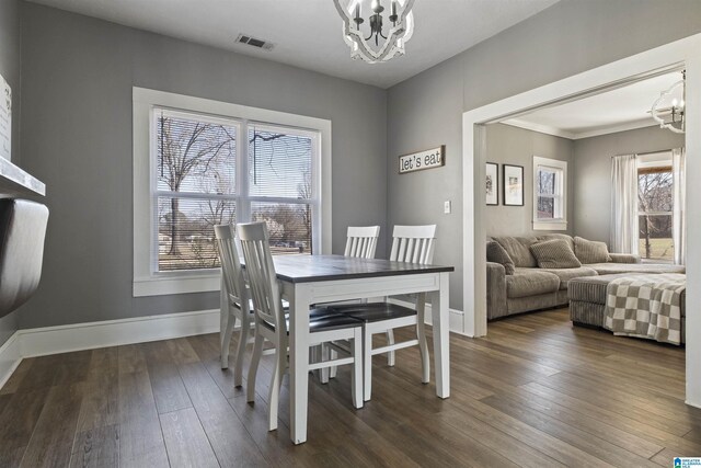 1109 Central Ave, Gadsden, AL 35904 - dining space with dark wood finished floors, visible vents, baseboards, and an inviting chandelier
