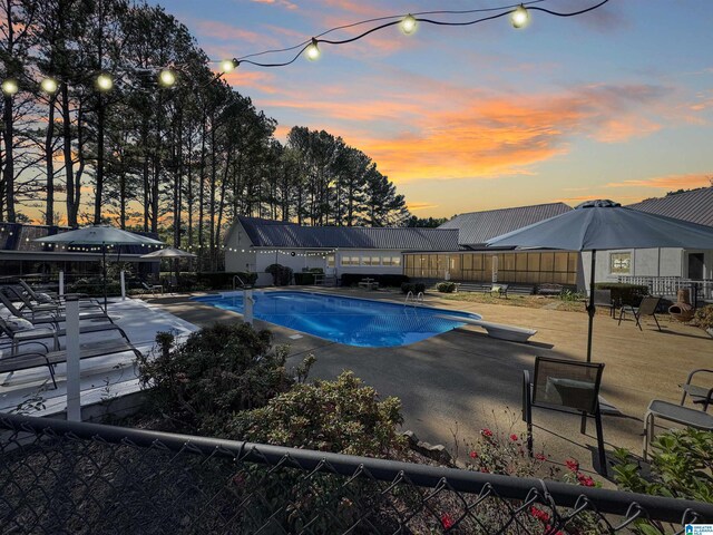 385 Rouse Rd, Sumiton, AL 35148 - pool at dusk featuring a patio area, a fenced in pool, fence, and a diving board