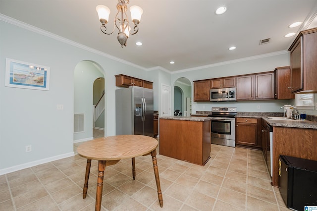 kitchen featuring visible vents, arched walkways, a sink, stainless steel appliances, and a kitchen island